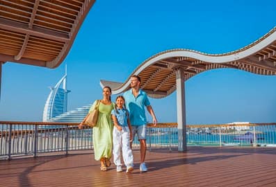 Small family taking a walk at Kite Beach promenade.