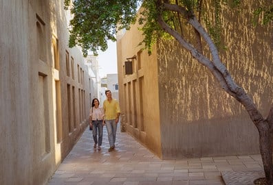 couple walking through the al fahidi historical neighbourhood