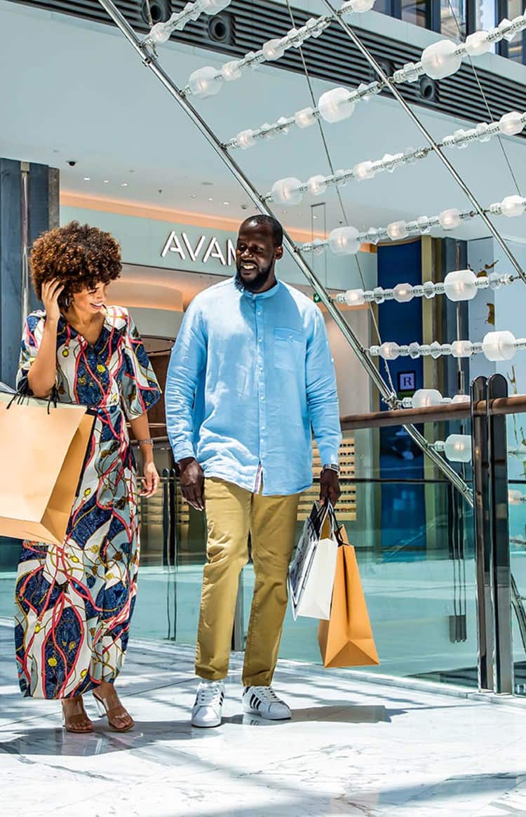 Couple walking with shopping bags in a mall in Dubai